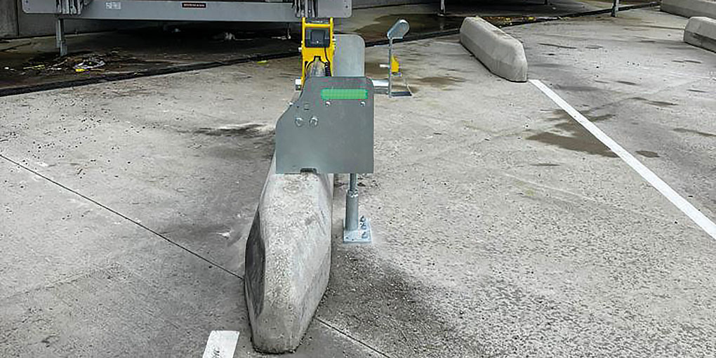 Wheel restraint installed on a concrete wheel guide in a loading bay.
