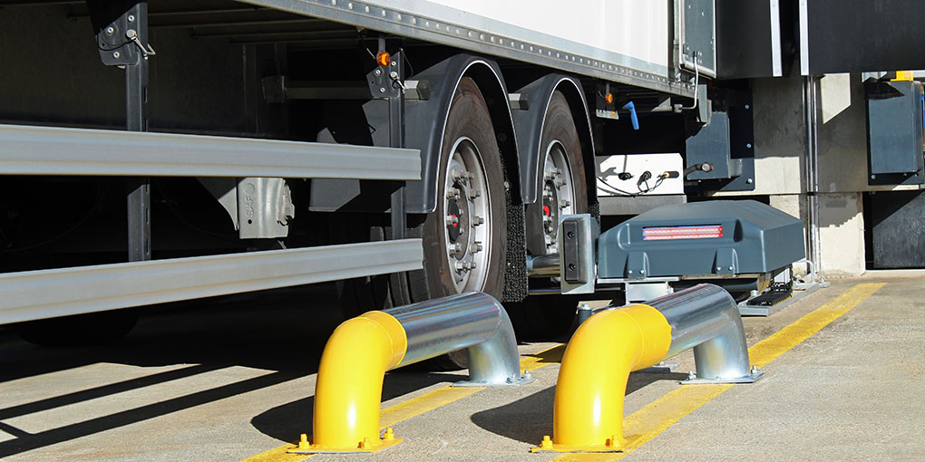 Truck wheel locking at the dock using a semi‑automatic wheel restraint.